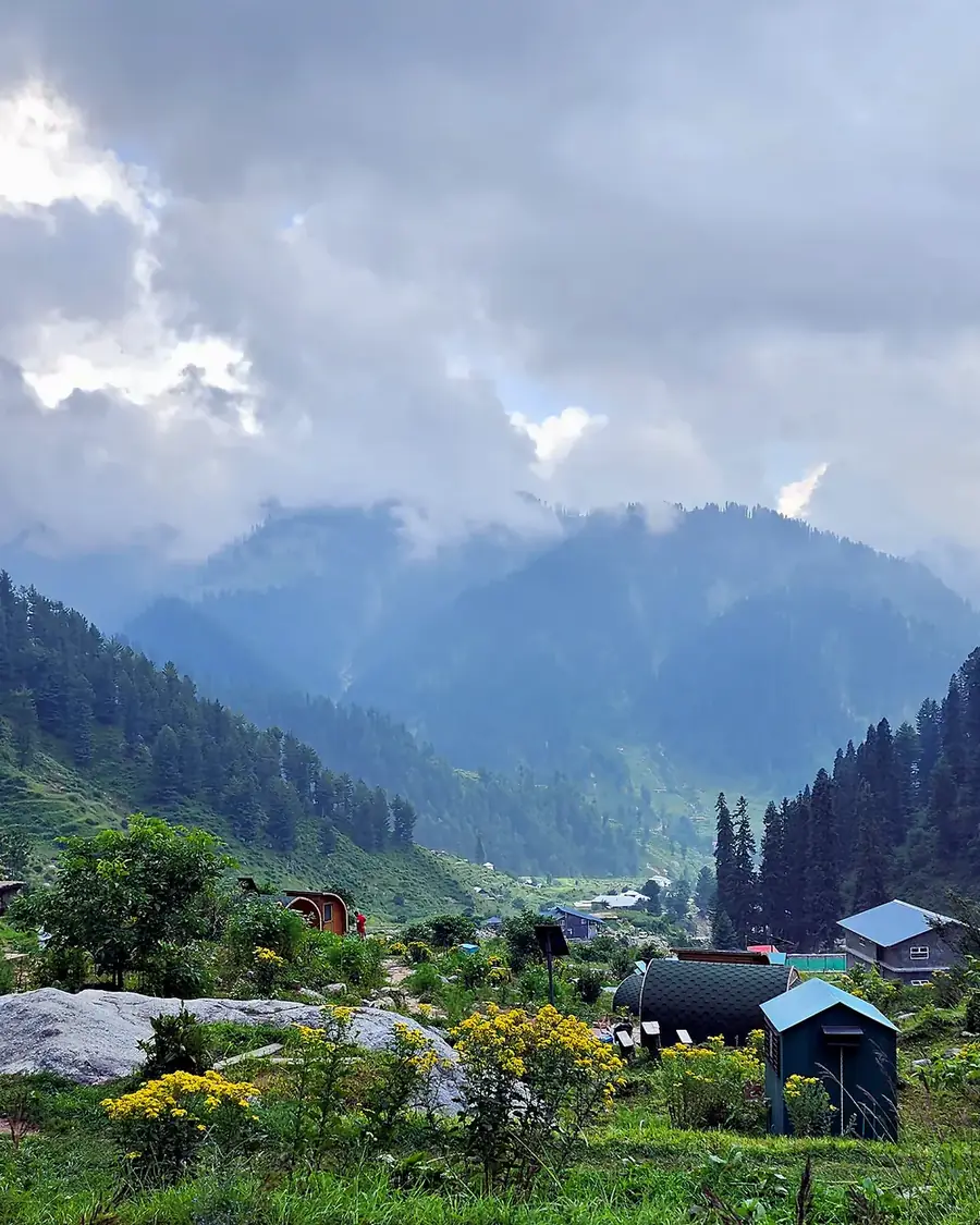 Glamping tents in a green mountain valley