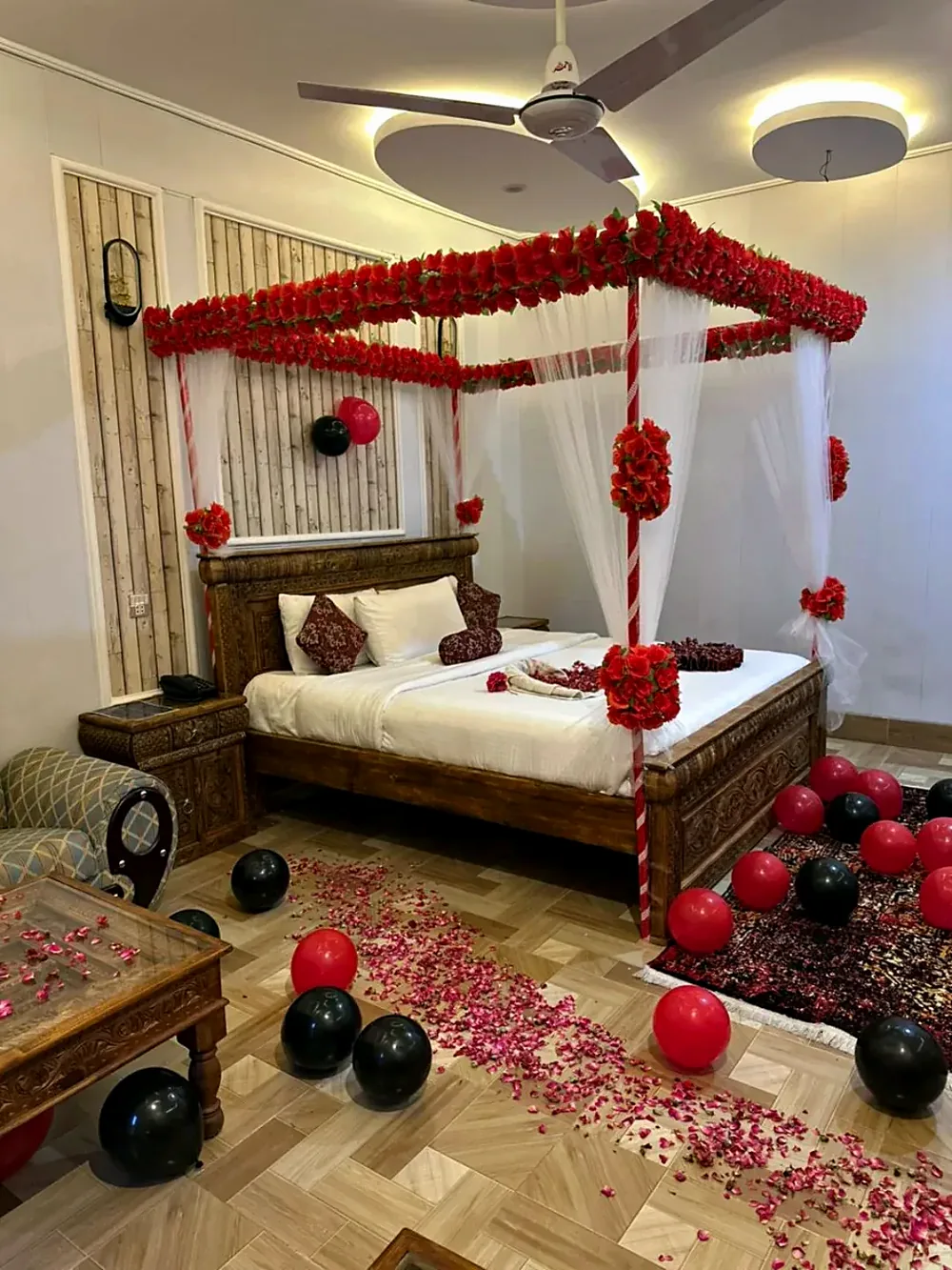 A bed decorated with red flowers for honeymooners