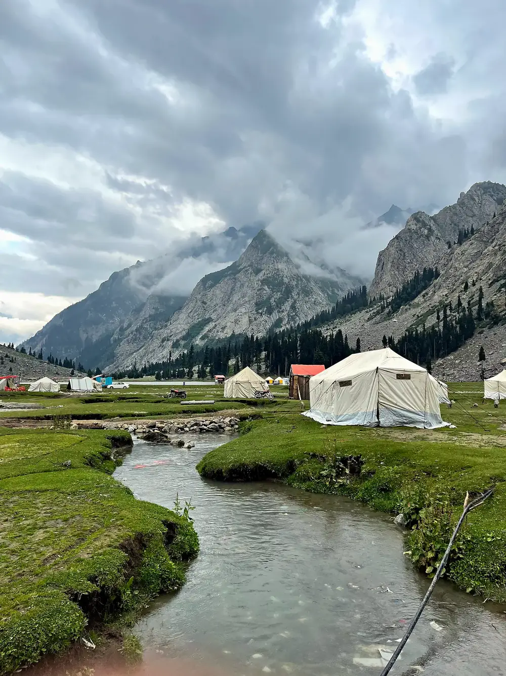 Canvas tents pitched by a mountain stream